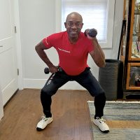 senior african american man exercising with weights squatting