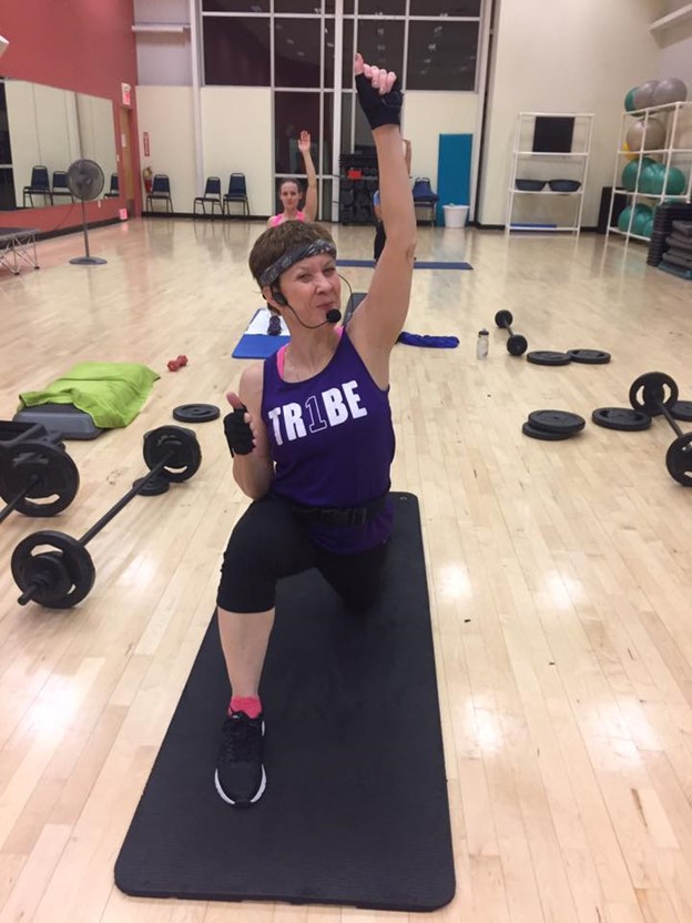 female fitness instructor teaching strength training class
