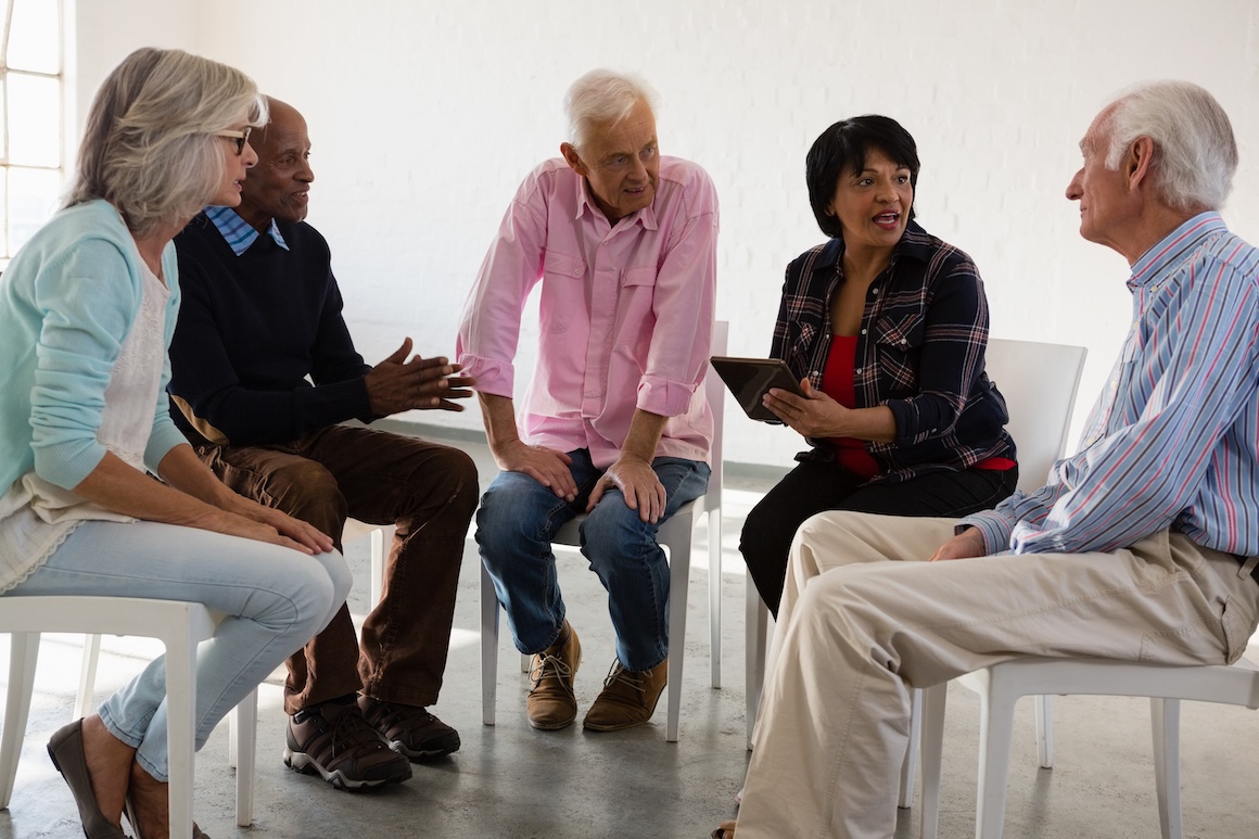 group of seniors having discussion in circle of chairs